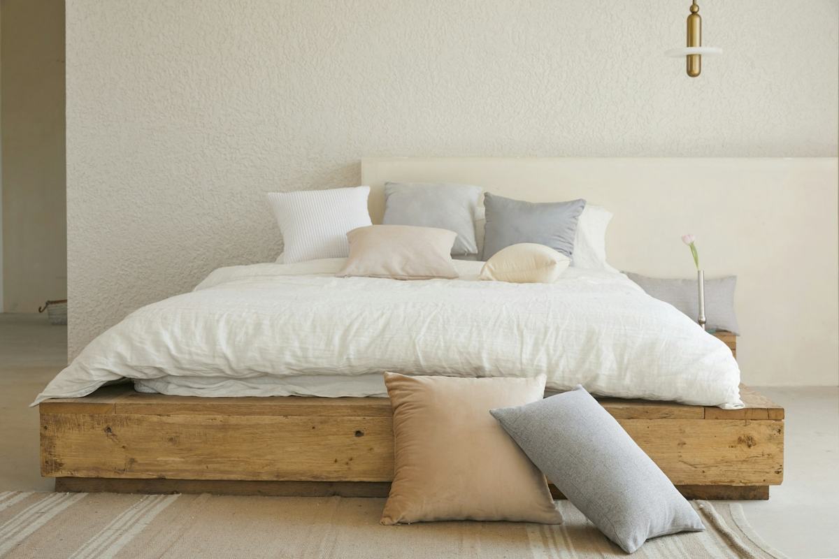 Cama com base de madeira e colchão branco